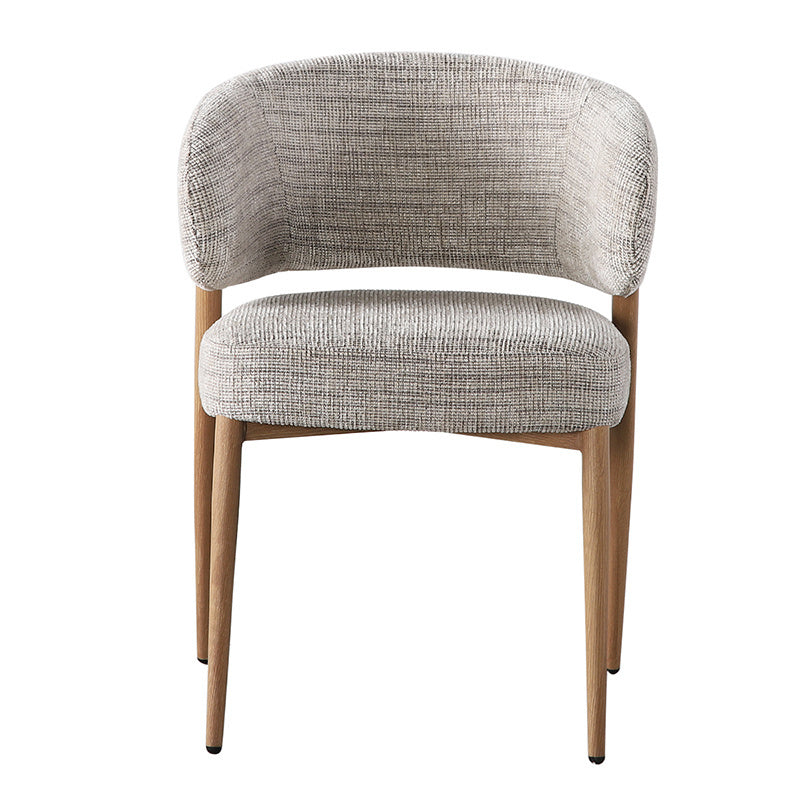 Vrijstaand recht vooraanzicht van de designstoel op een lichte achtergrond, tonend de symmetrische vormen, de zachte bekleding en het solide houten frame.